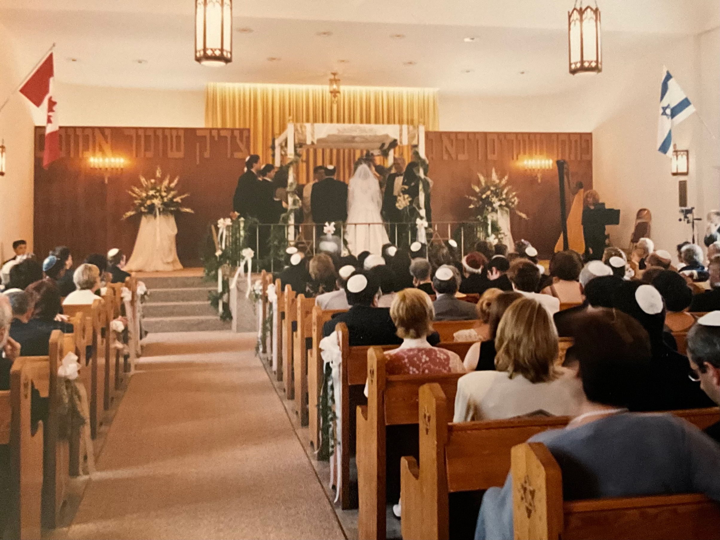 Image of Jewish wedding taking place in a crowded synagogue service.